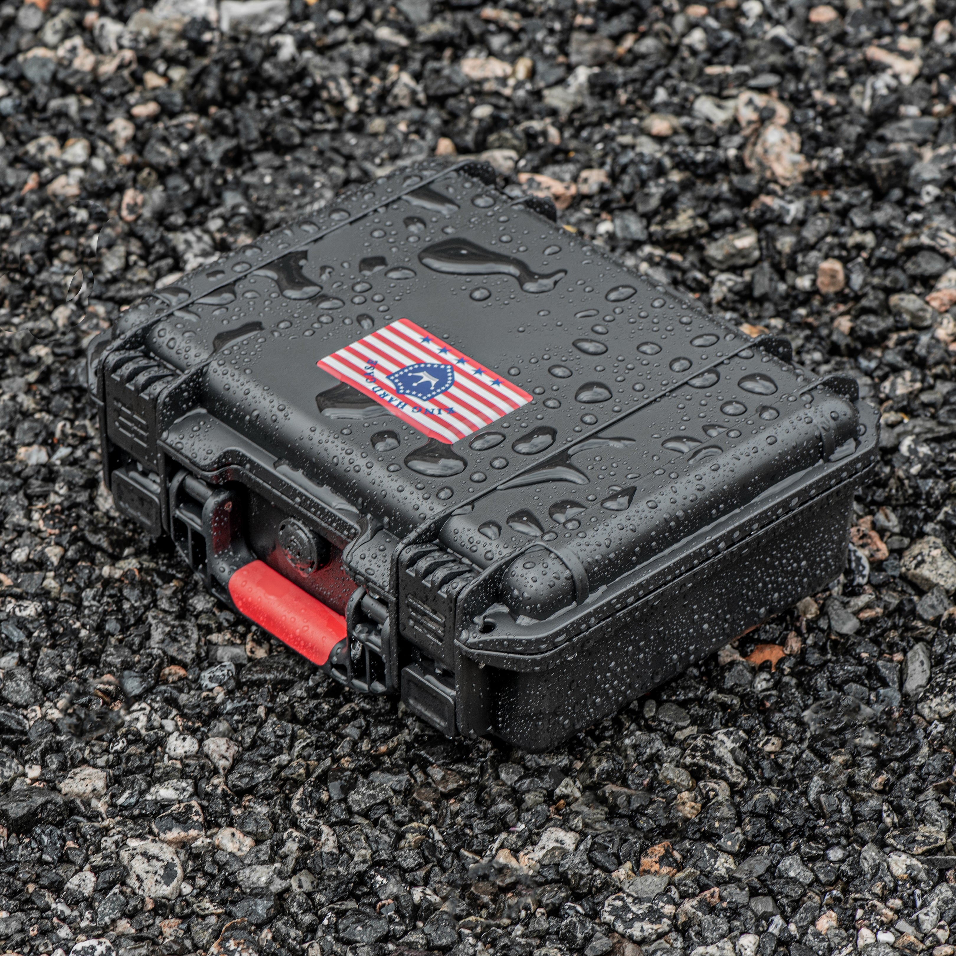 Rugged 11-inch 9mm waterproof ammo box sitting on wet gravel, demonstrating IP67 water resistance and shockproof design.