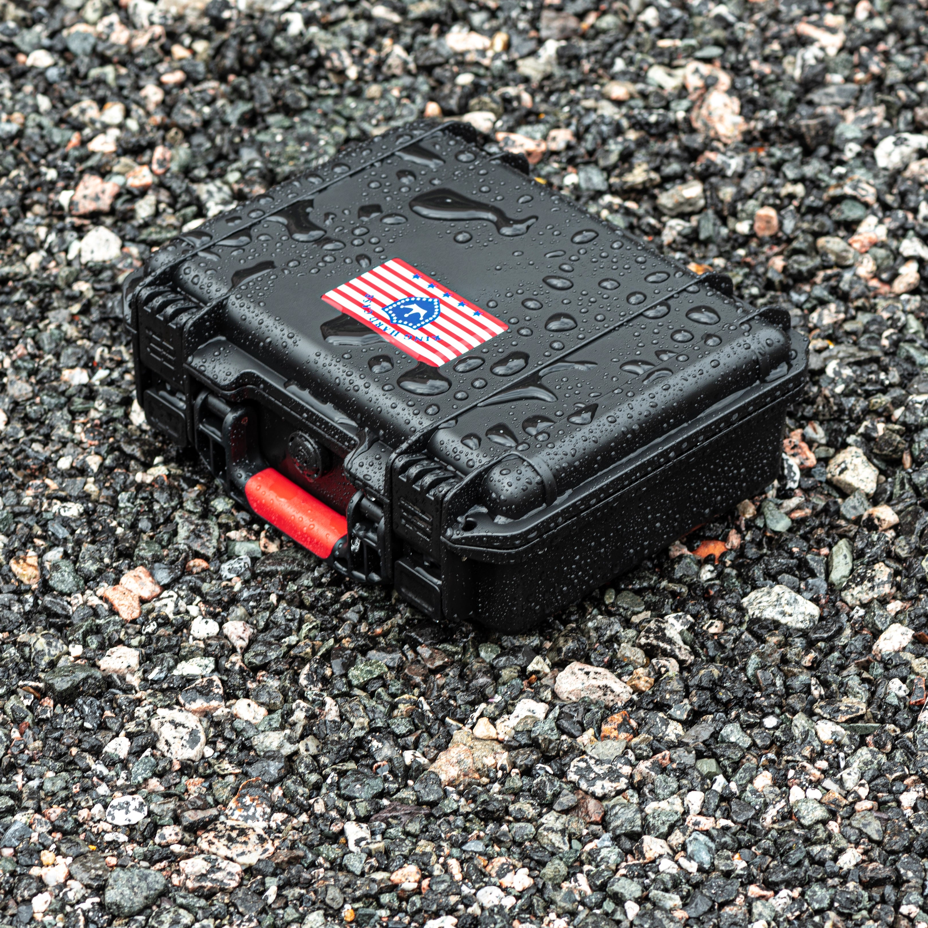 Rugged 11-inch waterproof weapon case sitting on wet gravel, demonstrating its IP67 waterproof rating and shockproof anti-collision design.